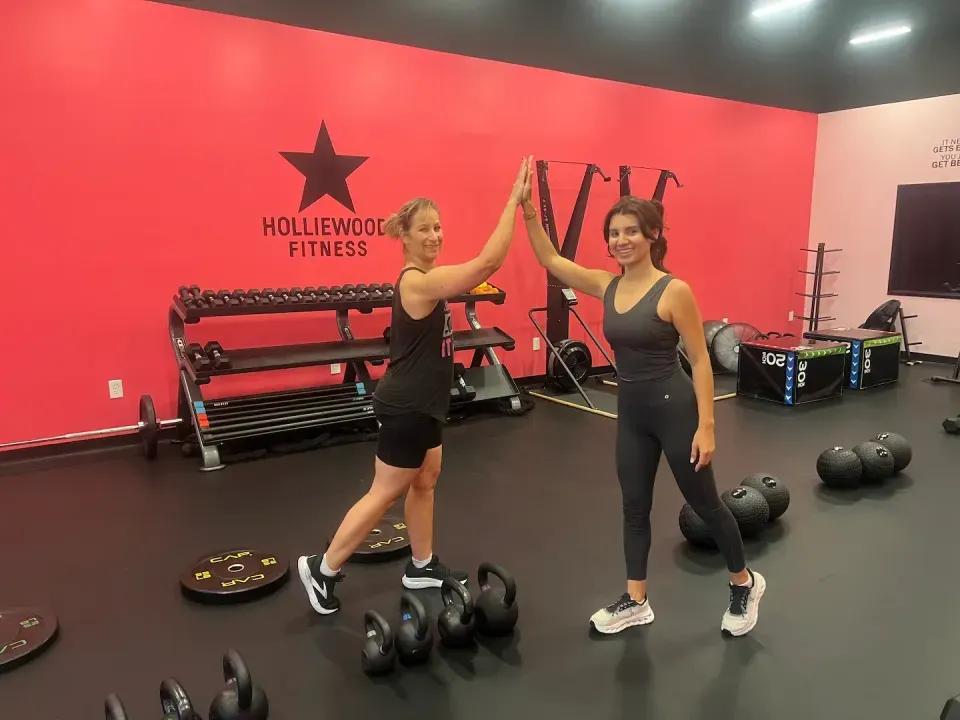 Two Holliewood Fitness members high-fiving after a coached workout